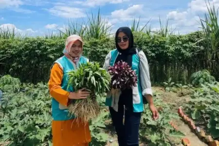 Murni (kiri), memamerkan hasil panen di kebun ketahanan pangan dan TOGA yang dikelola.