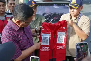 Rompi smart parking yang dilengkapi kode QRIS di bagian dada